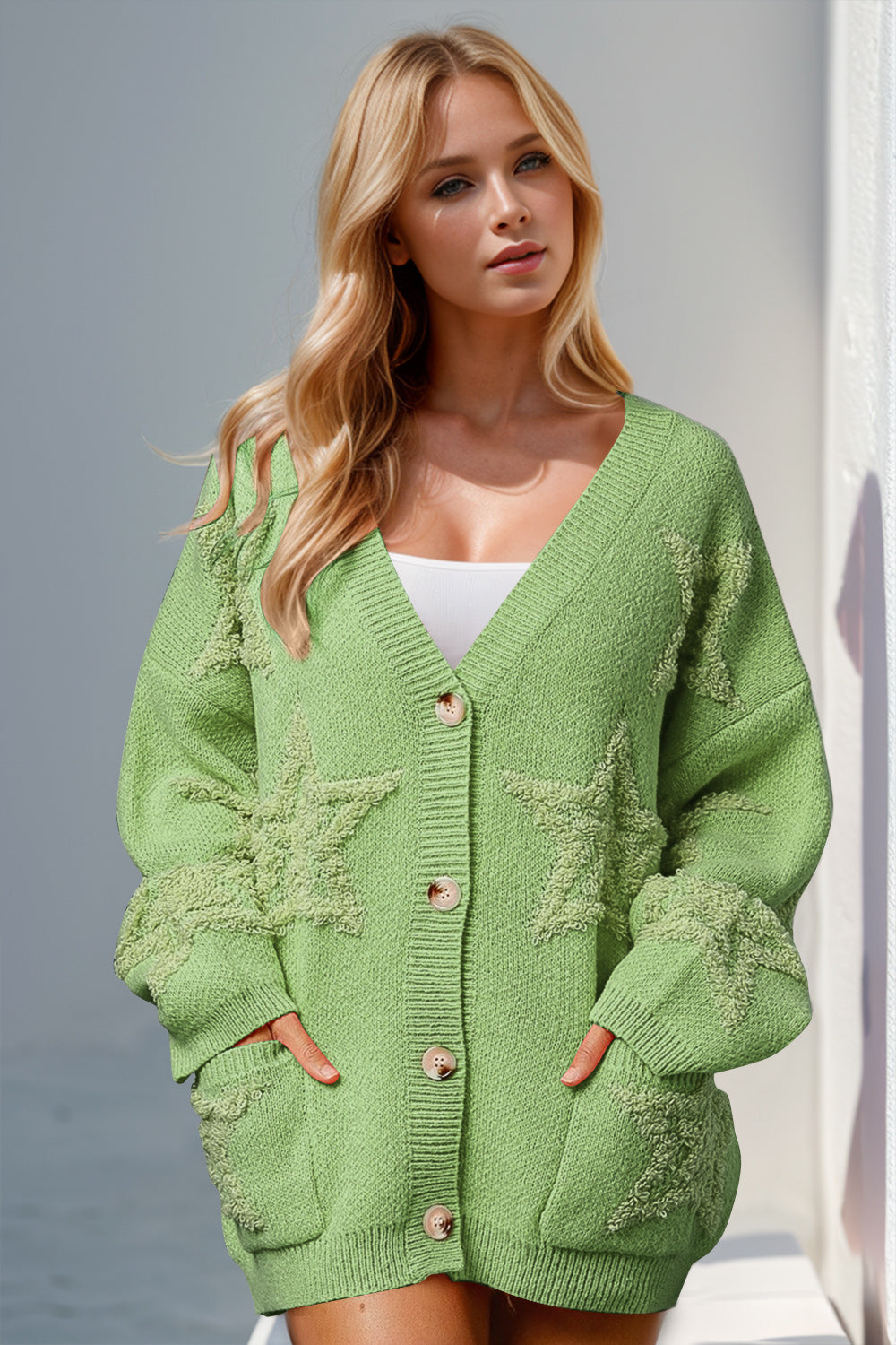Green textured starburst pocket cardigan with button front and V-neck.