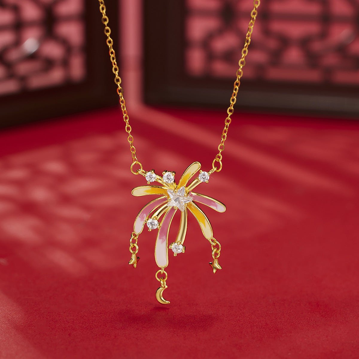 18k gold Starburst pendant necklace with pink & yellow enamel, cubic zirconia accents, and dangling stars & moon charms.