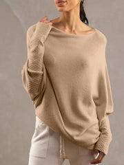 Off-shoulder knit sweater in cream with textured cuffs and batwing sleeves.