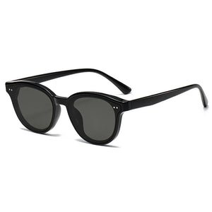 Black round frame sunglasses with dark lenses and silver dot accents.