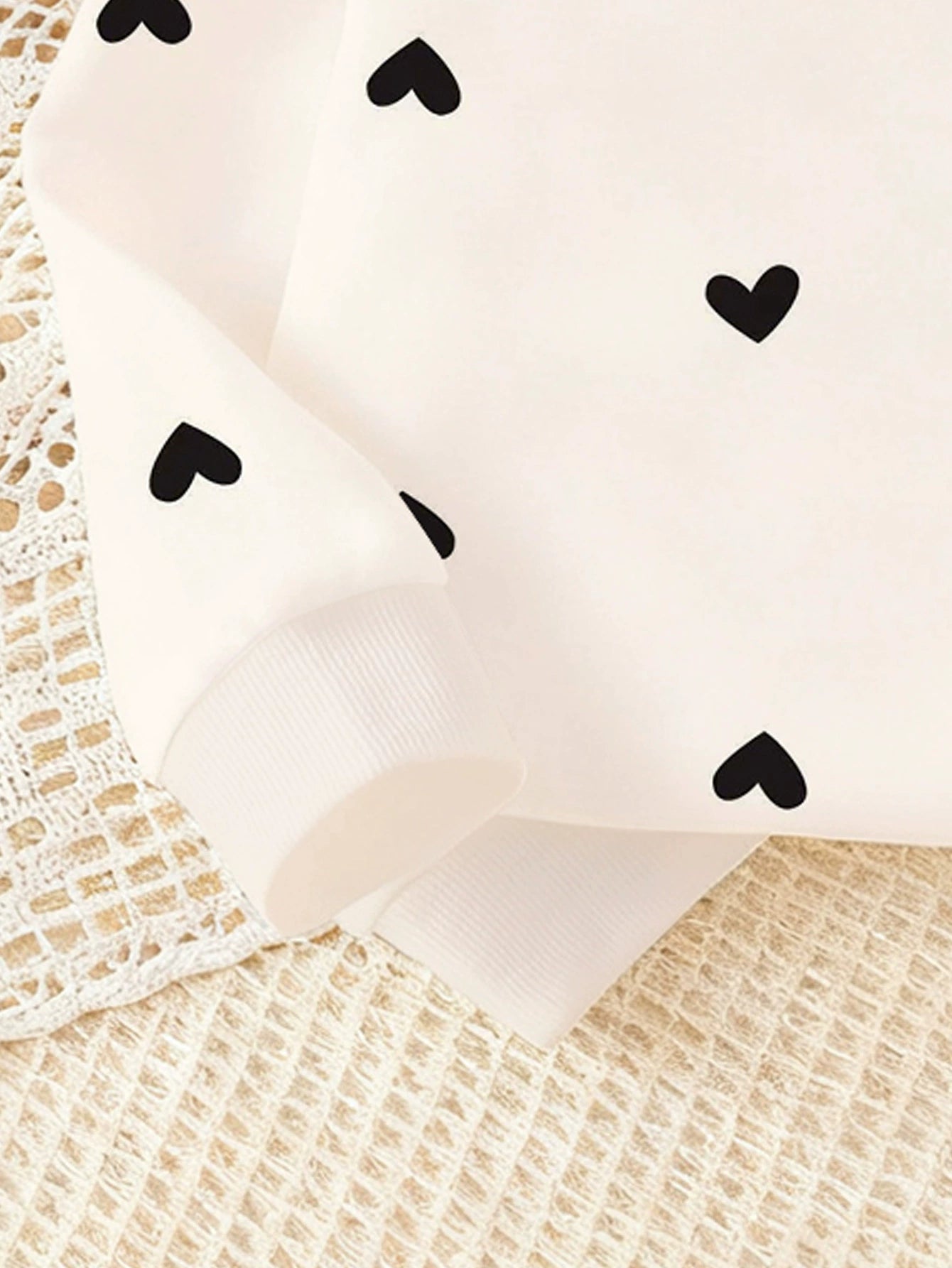 Baby top with black heart print and ribbed cuff detail