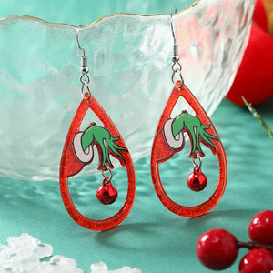 Red acrylic teardrop Grinch hand earrings with dangling bells.