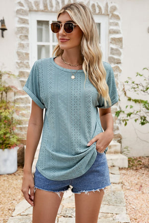 Teal perforated sleeve tee with rolled cuffs and crew neck, styled with denim shorts.