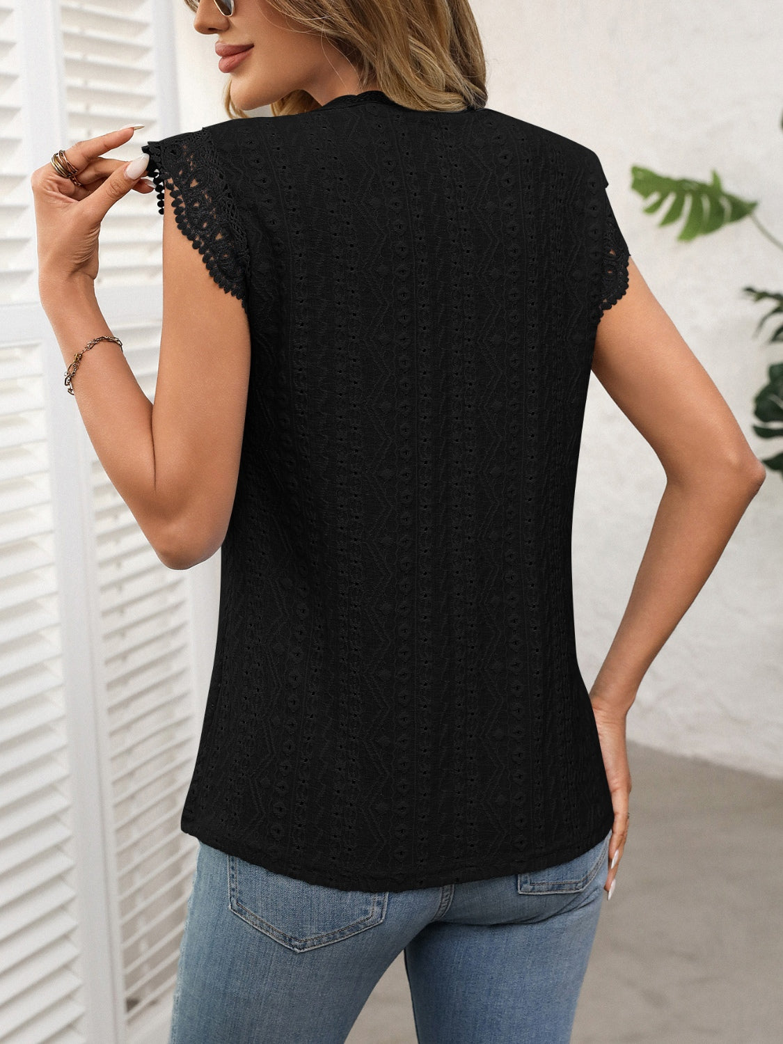 Black eyelet cap sleeve blouse with lace trim and beaded detail on sleeves.