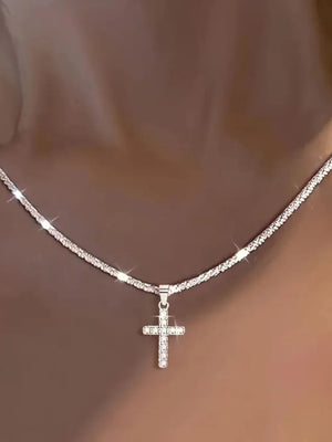 Sparkling silver cross pendant necklace with pave crystal detail on a textured chain.