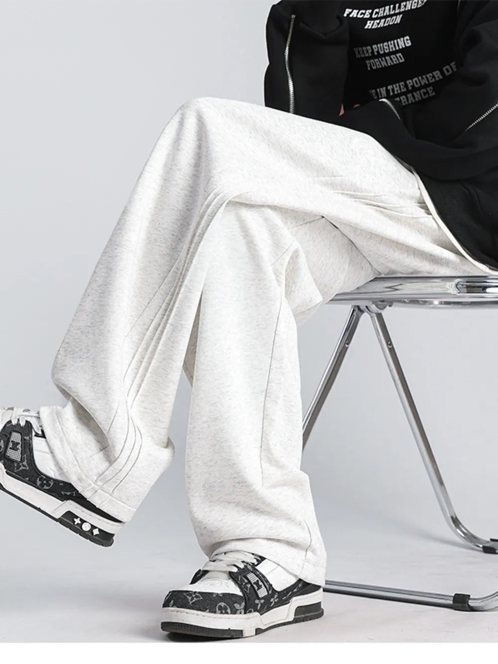 Men's gray heather sweatpants with a loose fit and wide leg, styled with sneakers.