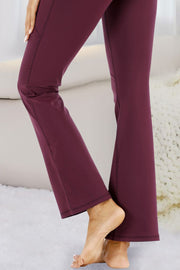 Burgundy flare-leg performance trousers with pockets and visible seams.