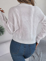 White cable knit sweater with open knit details and ribbed hem.