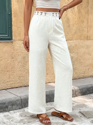 White wide-leg pants with textured fabric and a crochet waistband detail.