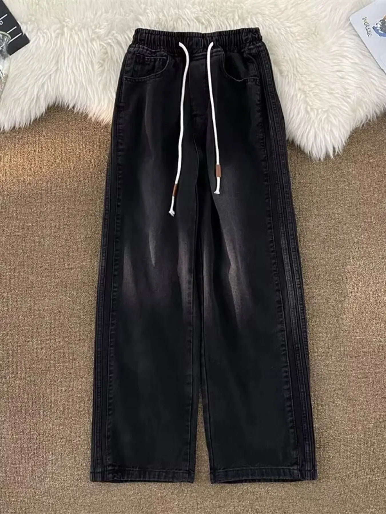 Black wide-leg drawstring jeans with a relaxed fit and denim material.