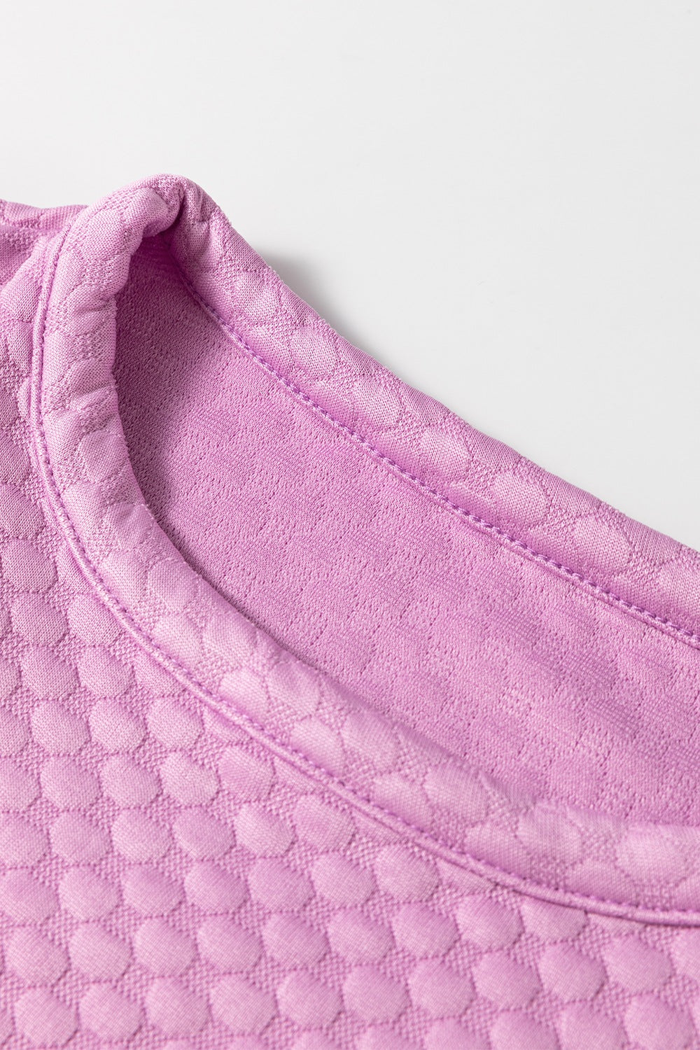 Pink purple textured quilted blouse with a round neckline and puff sleeves.