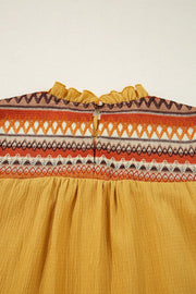 Mustard blouse with embroidered yoke and ruffled neckline detail.