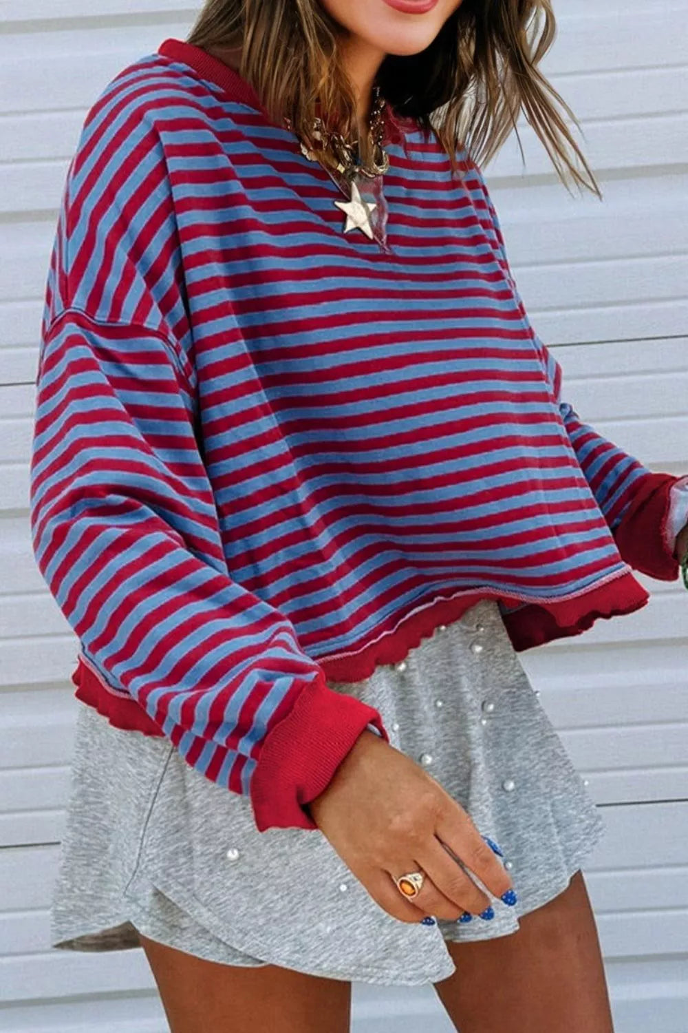 Striped sweatshirt with red and blue stripes, crew neck, and contrast red trim.