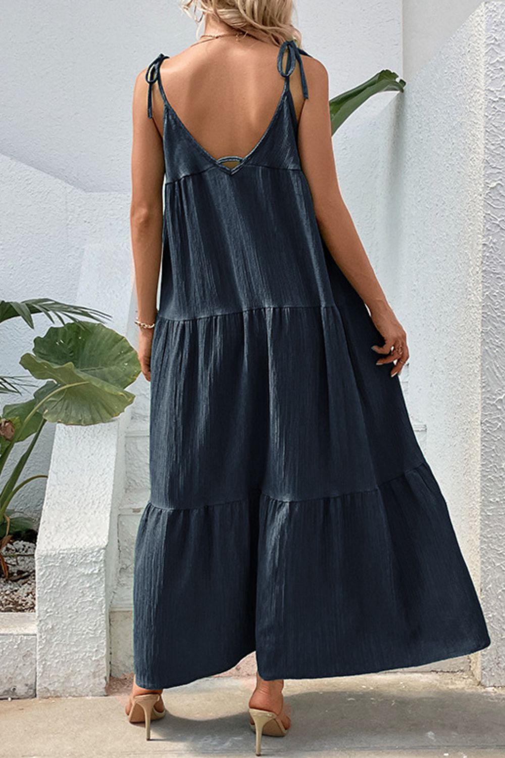 Dark blue tiered maxi dress with tie straps and textured fabric.
