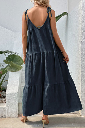 Dark blue tiered maxi dress with tie straps and textured fabric.