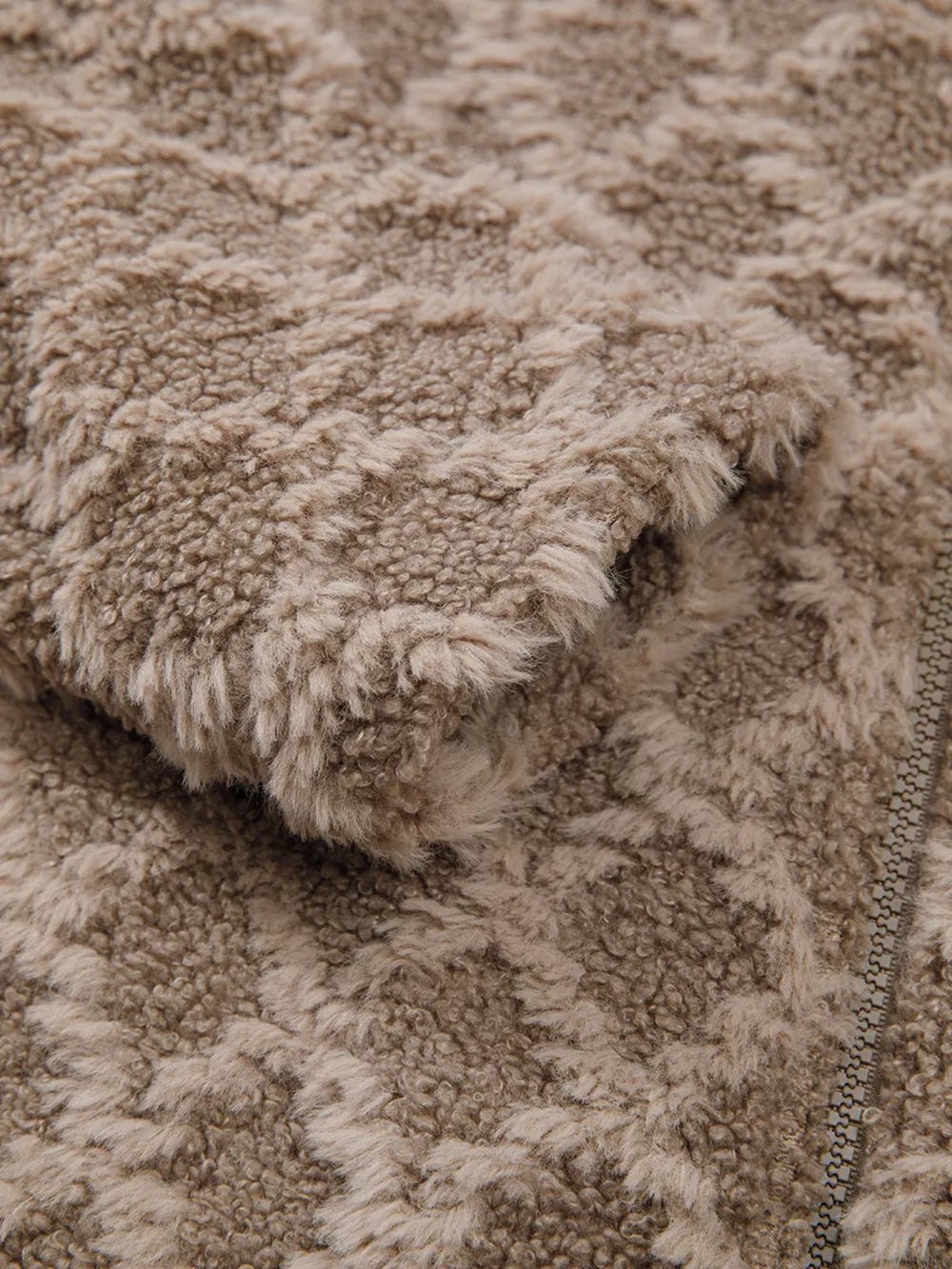 Textured sherpa fleece hooded jacket in tan with a subtle geometric pattern and zipper detail.