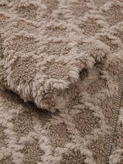 Textured sherpa fleece hooded jacket in tan with a subtle geometric pattern and zipper detail.