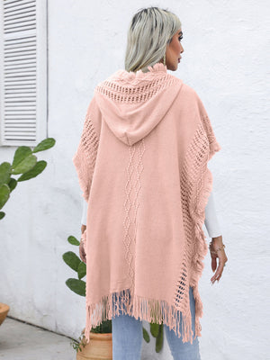 Textured knit poncho in watermelon pink with fringe, hood, and diamond pattern detail.