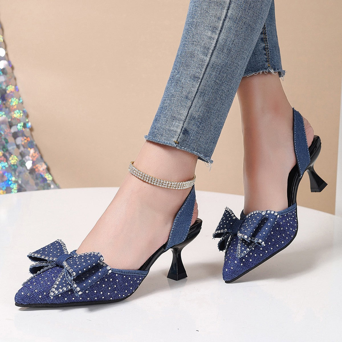 Blue denim slingback heels with rhinestone bowknot detail and ankle strap.