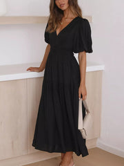 Black midi dress with puff sleeves, V-neck, and tiered skirt.