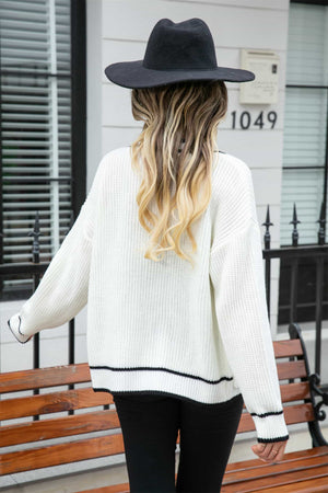 White acrylic cardigan with black trim detail on hem and cuffs