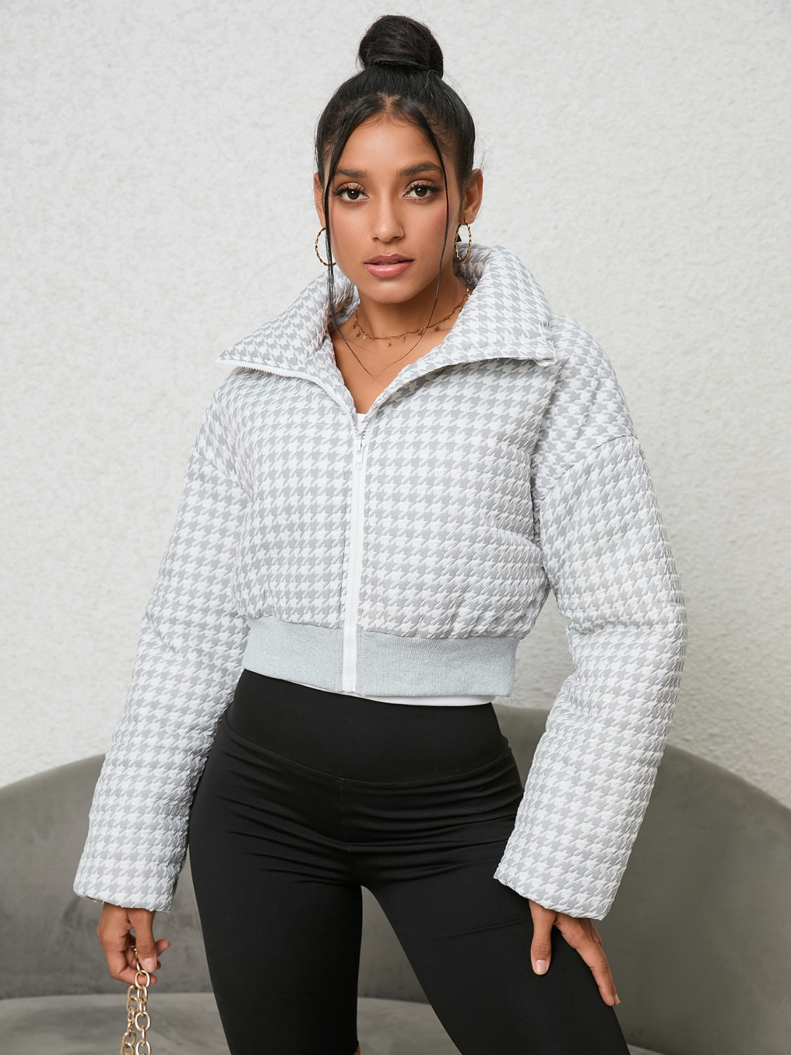 White houndstooth padded jacket with a cropped fit and high collar, zipped front.