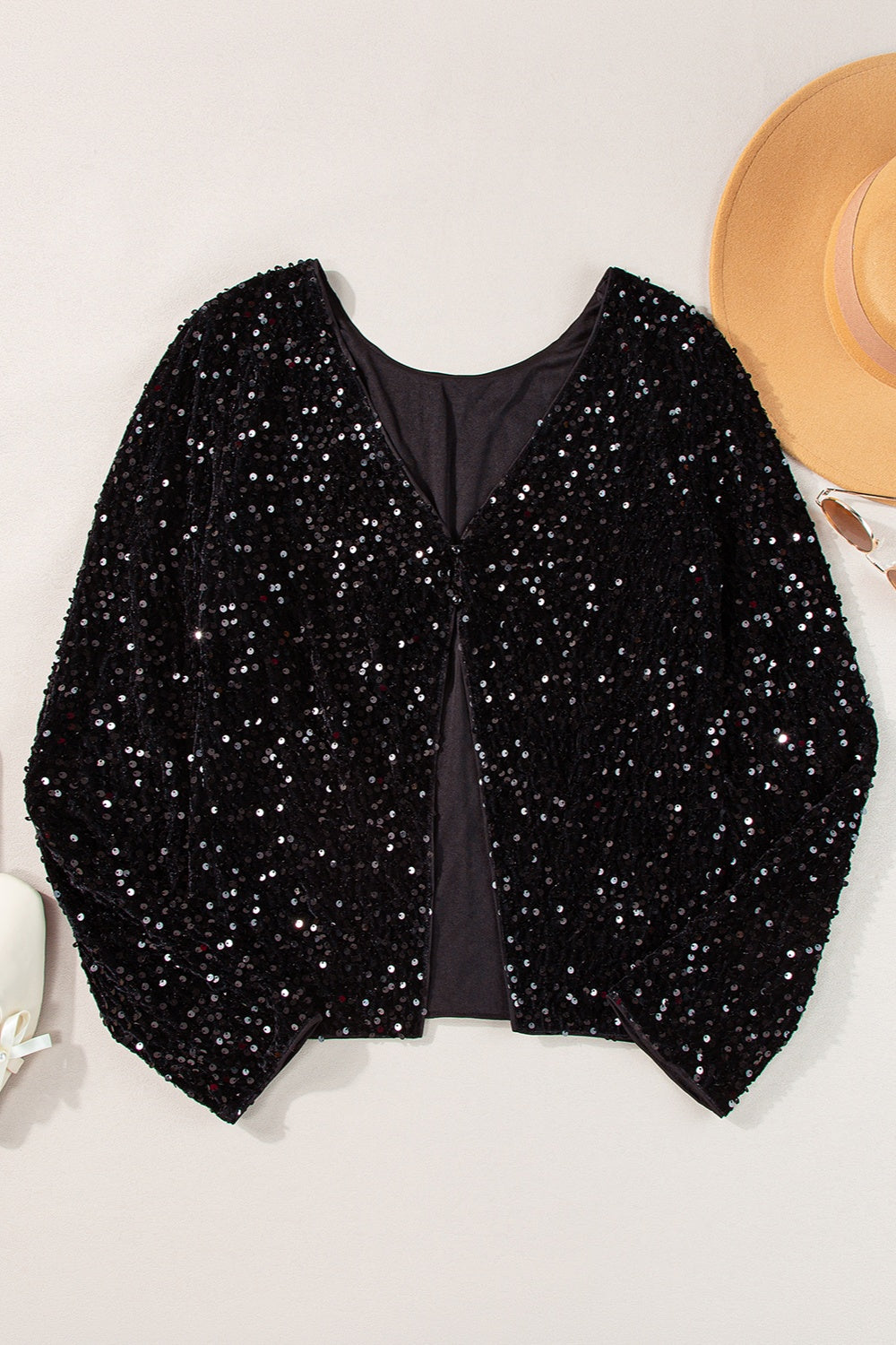 Black sequin backless blouse with V-neck and long sleeves.