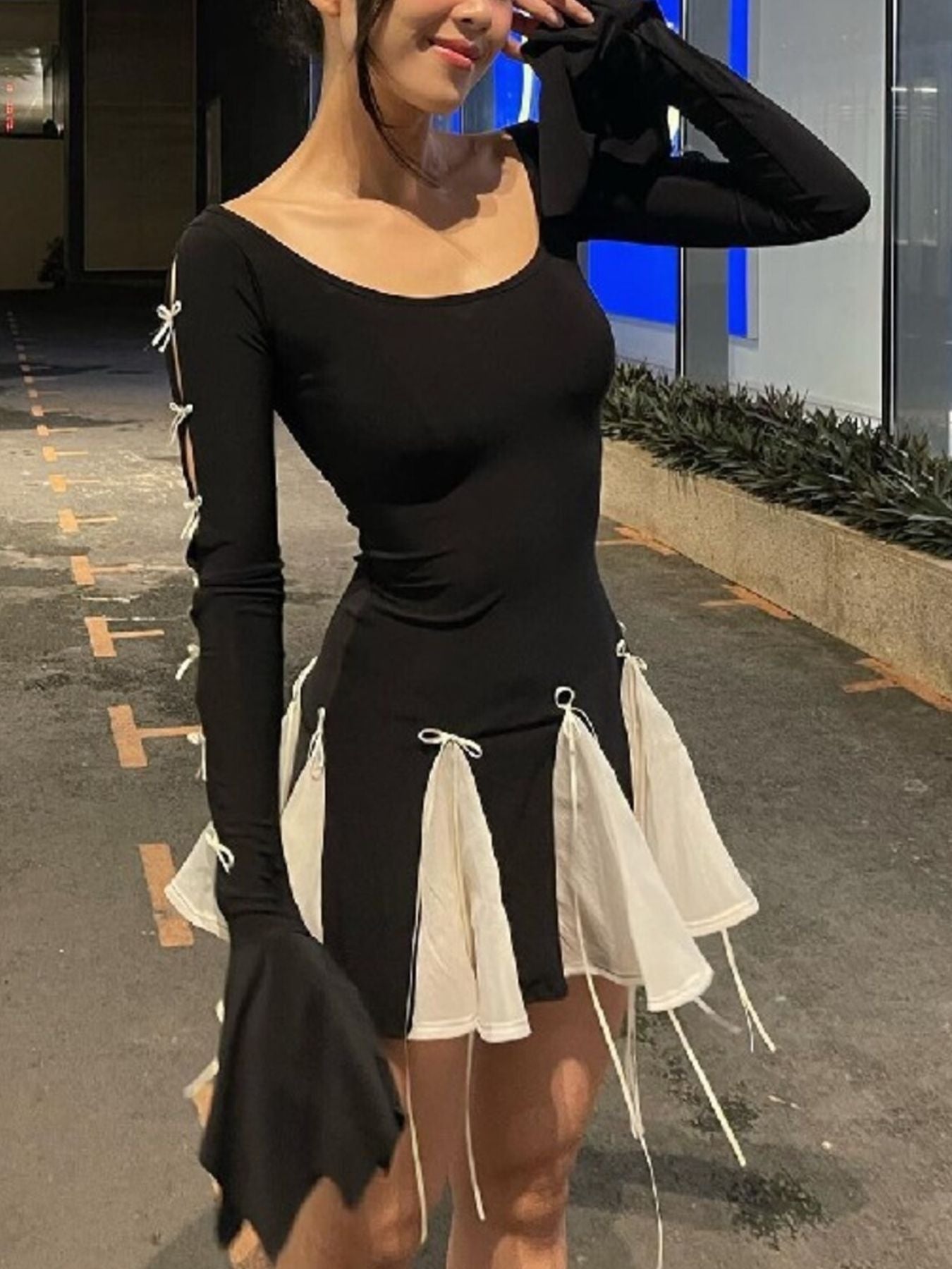 Black mini dress with bowknot details on sleeves and skirt with white fabric accents