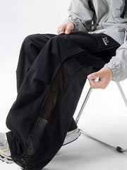 Black cargo sweatpants with mesh side panels and adjustable waist.