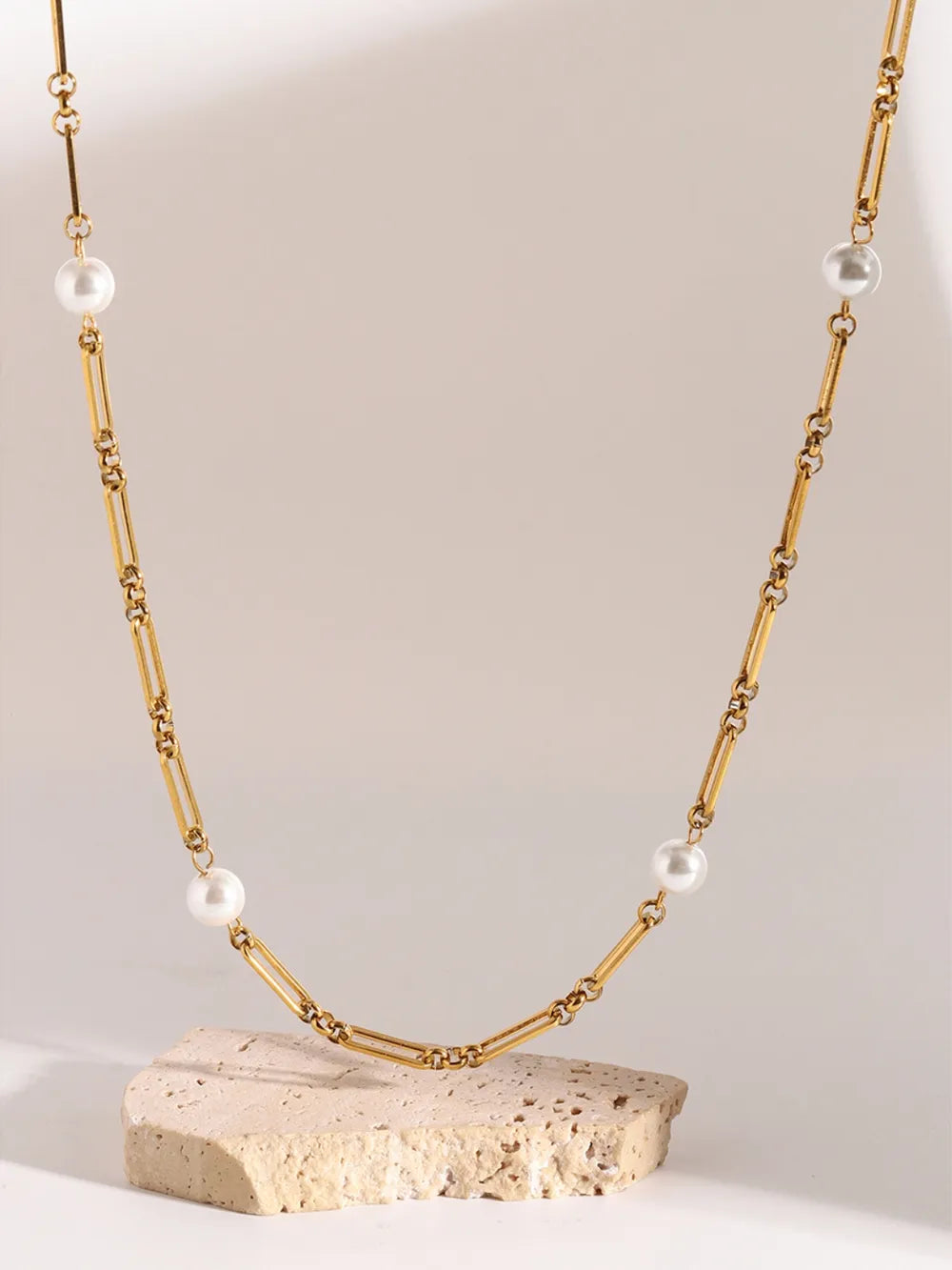 Gold two-tone pearl link necklace with rectangular chain links and white pearls.