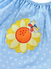 Baby dress with embroidered sunflower and butterfly detail on light blue floral print cotton fabric.
