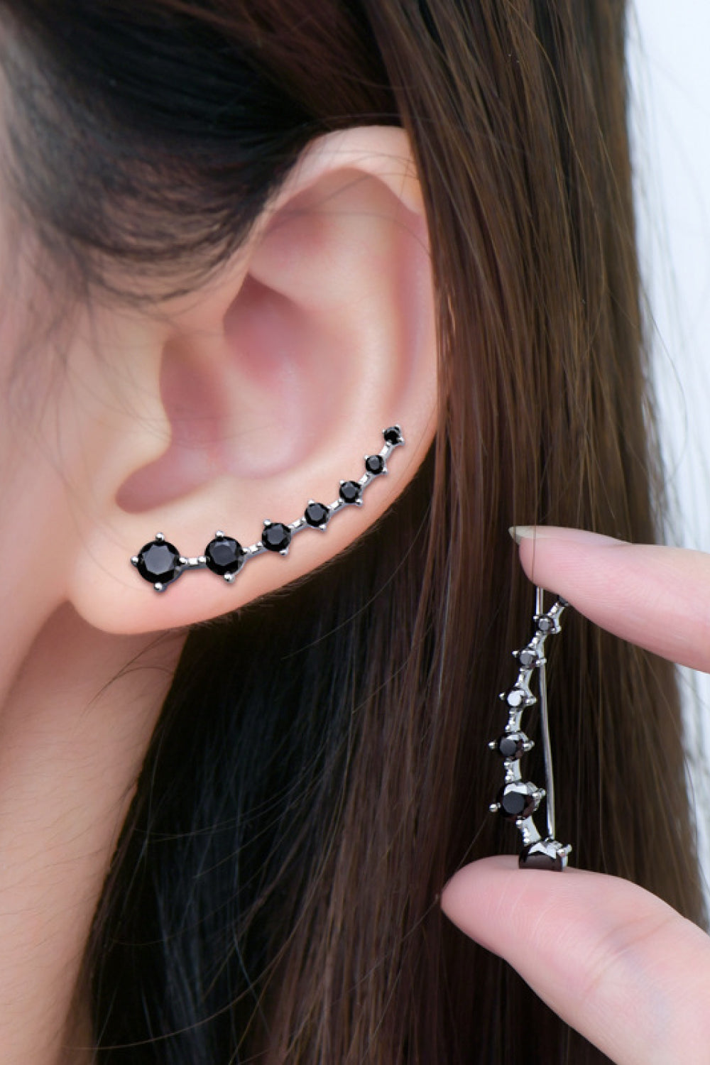 Black diamond ear climbers with a curved design, showcasing multiple black stones on a silver setting.