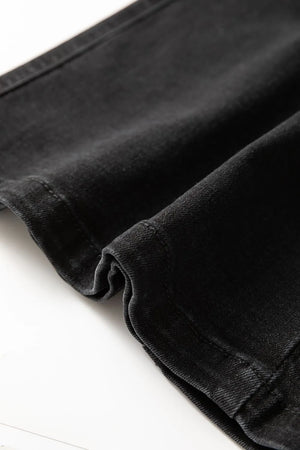 Black denim midi skirt detail showing fabric texture and stitching.