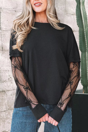 Black maternity t-shirt with lace sleeves featuring a bow pattern and relaxed fit.