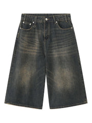 Wide-leg distressed denim culottes in dark wash with button fly and frayed hem.