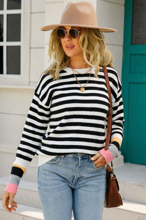 Black and white striped sweater with colorblock cuffs in pink, gray, yellow, and black.