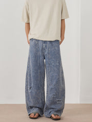 Men's blue acid wash distressed wide-leg denim jeans with ripped details.