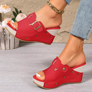 Red wedge sandals with decorative accents and gold buckle detail.