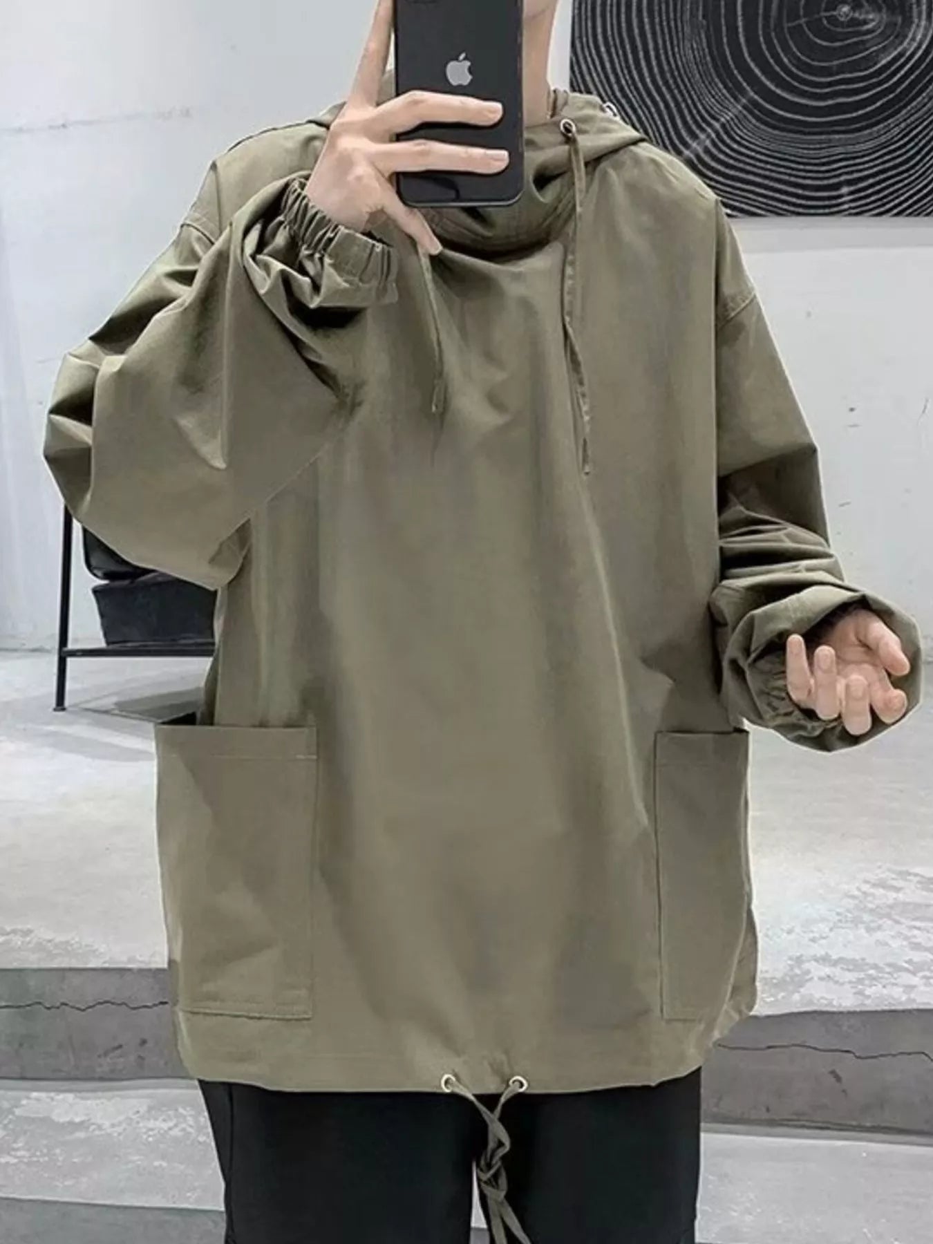 Oversized green drawstring hoodie with elastic cuffs, large front pockets, and adjustable hem.