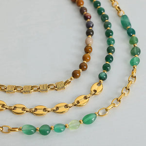 Gilded bead and chain statement necklaces in green and mustard tones with gold accents.