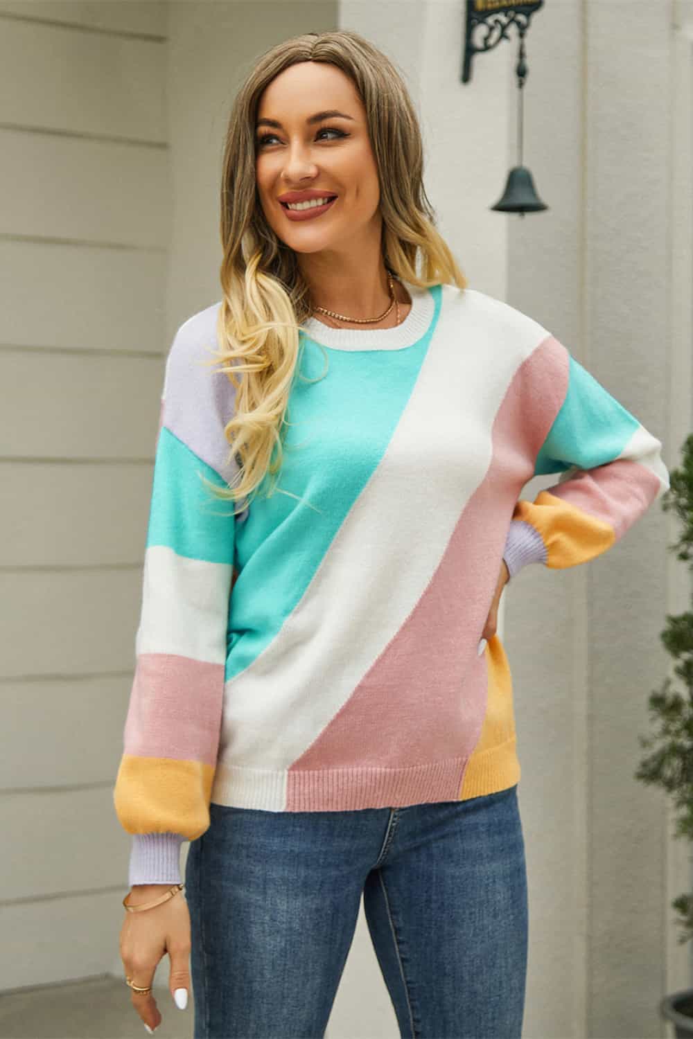 Geometric colorblock knit crewneck sweater with pastel diagonal stripes and ribbed cuffs.