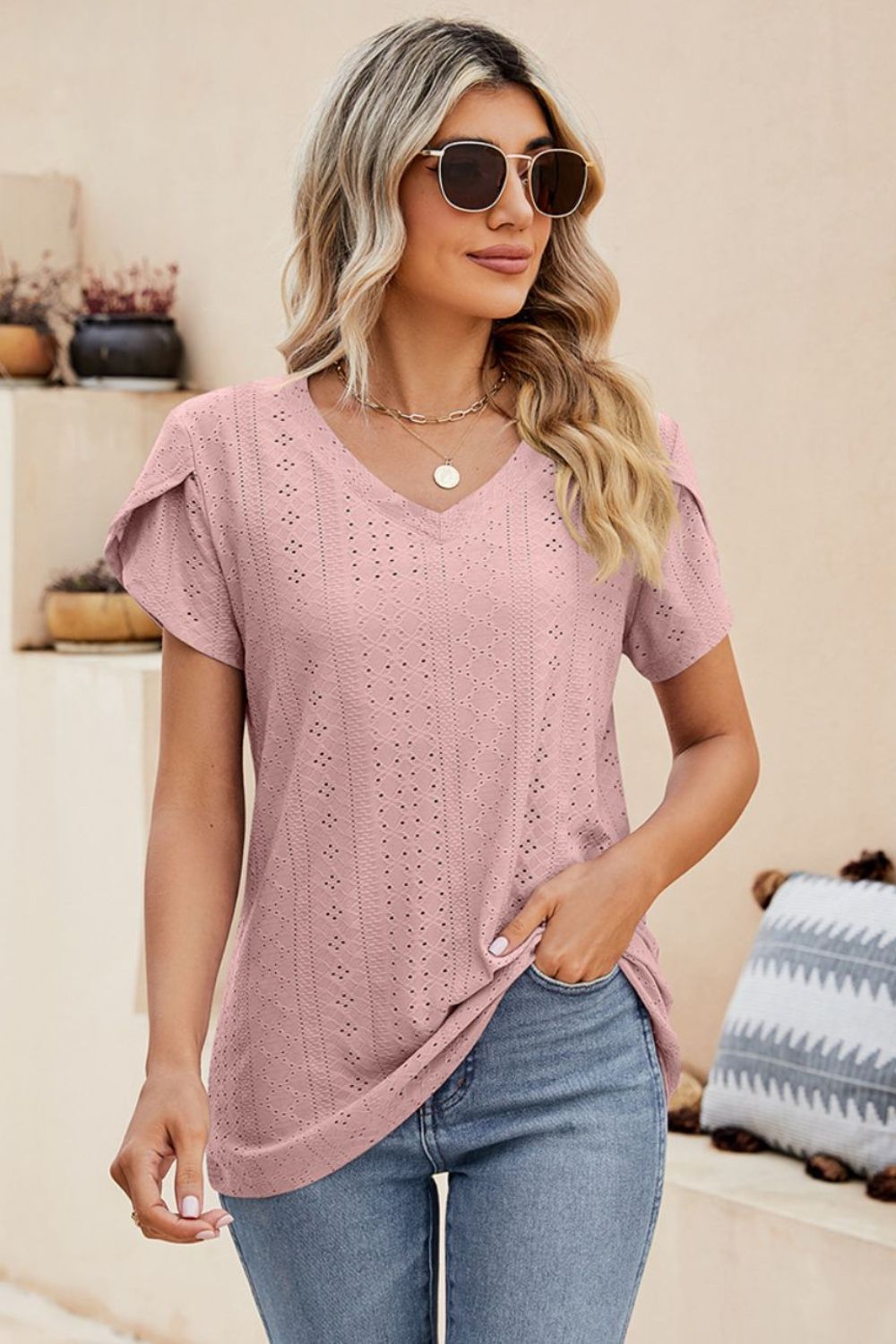 Blush pink knit top with perforated sleeve detail and v-neck