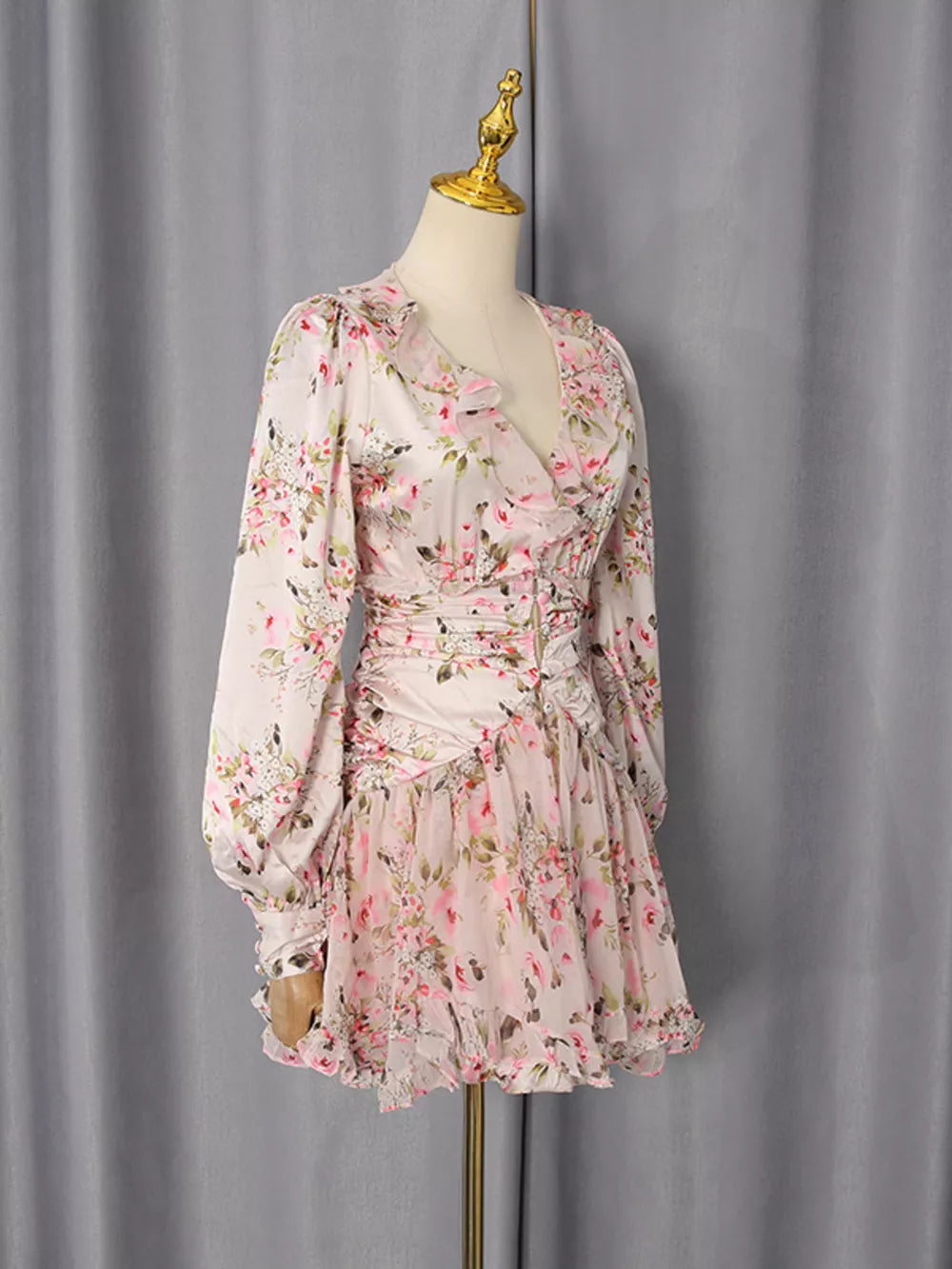 Charming floral mini dress with ruffles, V-neck, and long sleeves.