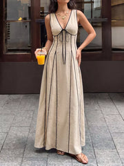 Elegant beige maxi dress with black piping and tie-front neckline.