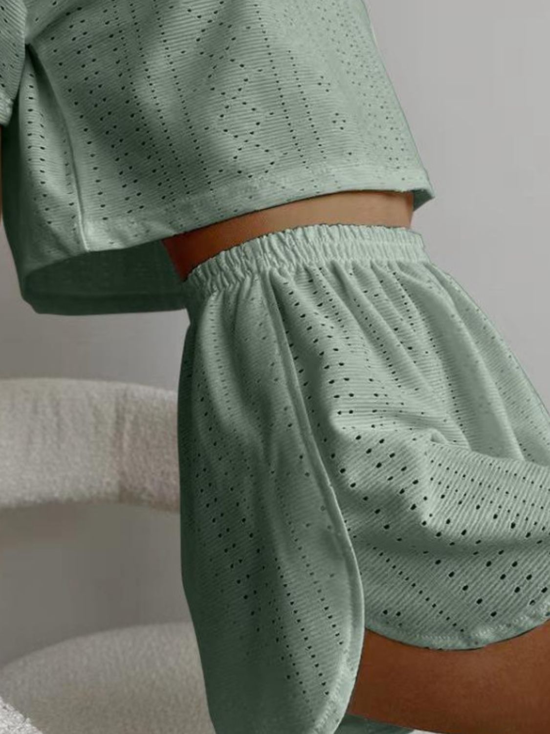 Sage perforated crop top and shorts set with elastic waistband and breathable fabric.