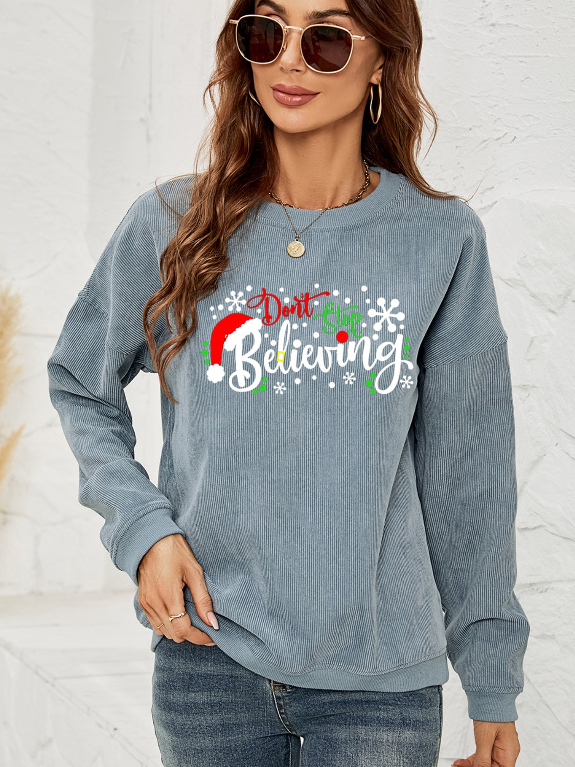 Misty Blue corduroy crewneck sweatshirt with a Christmas graphic that says "Don't Stop Believing.