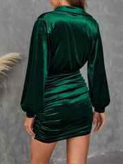 Elegant dark green velvet mini dress with ruched detailing and long balloon sleeves.