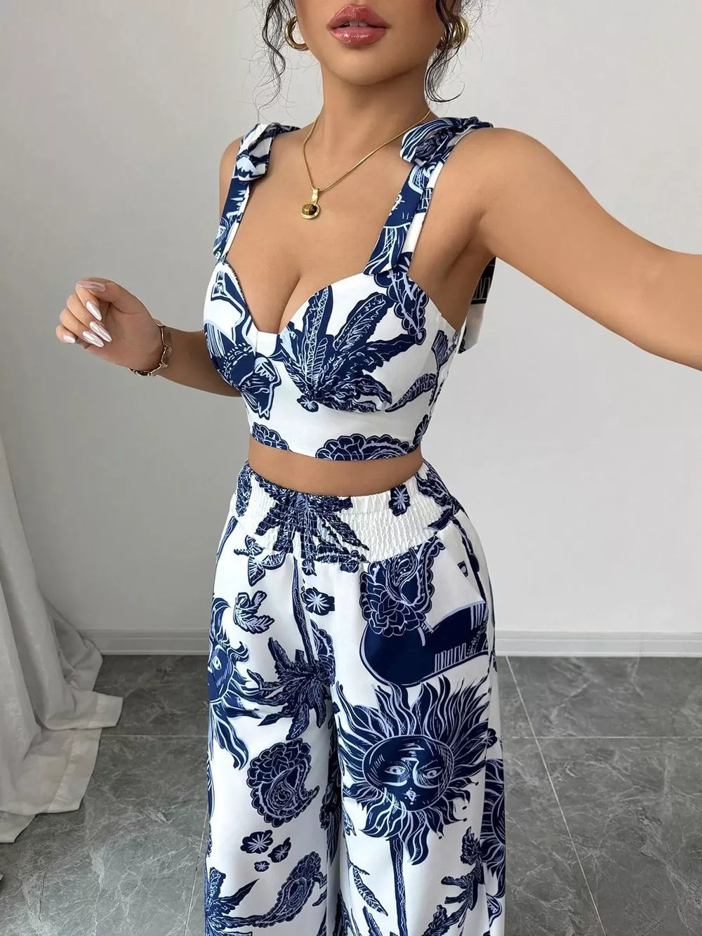 Blue and white tropical print crop top and wide-leg pants set with tie straps.