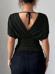 Black ruched surplice tunic with dolman sleeves and smocked waist detail.