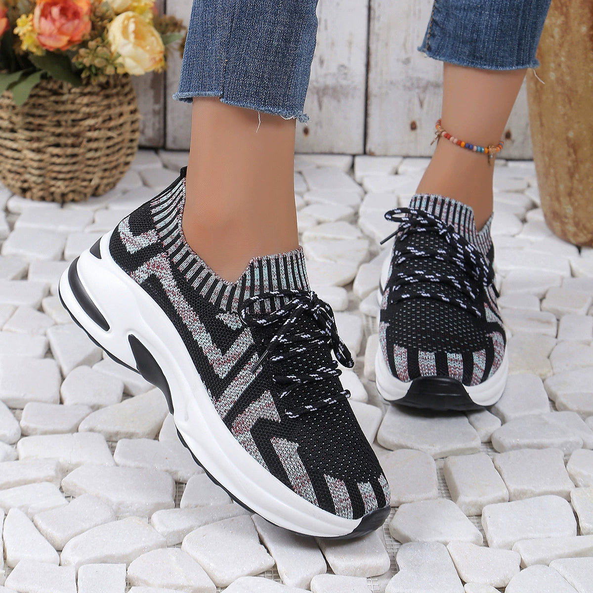 Geometric knit platform sneakers in black with white laces and a chunky white sole.